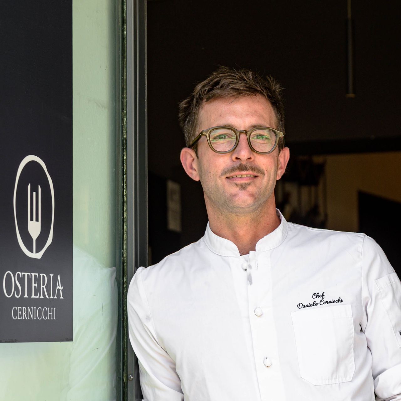 Ritratto dello chef Daniele Cernicchi sulla porta dell'Osteria